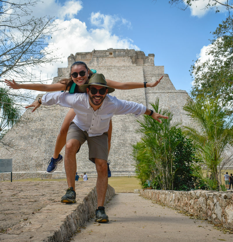 Pareja viajando frente a ruinas