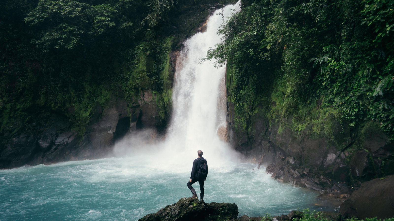 Viajero frente a una cascada en la selva
